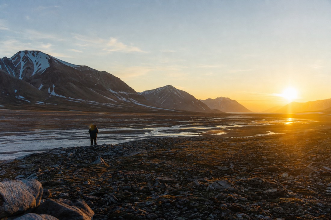 Midnight sun low over Adventdalen valley near Longyearbyen in the polar summer